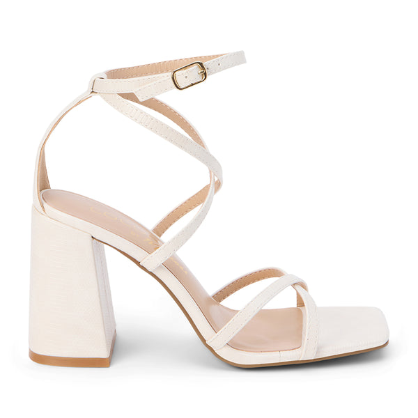 Women's ivory strappy block heel sandal with a square toe and adjustable ankle strap, featuring a minimalist design and smooth faux leather finish.