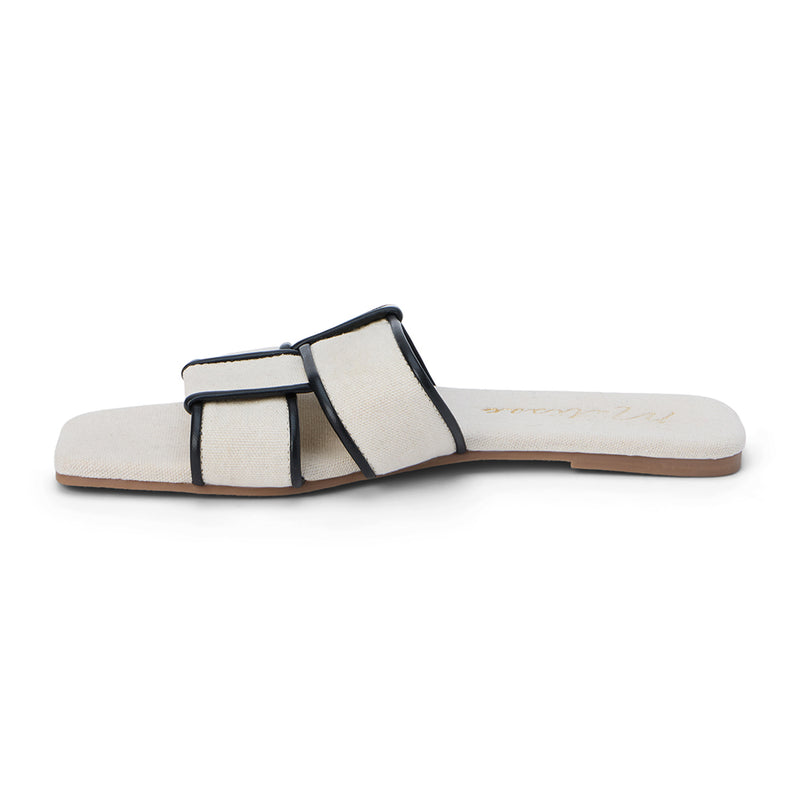 Chic flat slide sandals in an ivory fabric with black-trimmed crisscross straps. Featuring a square toe and minimalist design, these sandals are perfect for effortless summer style.