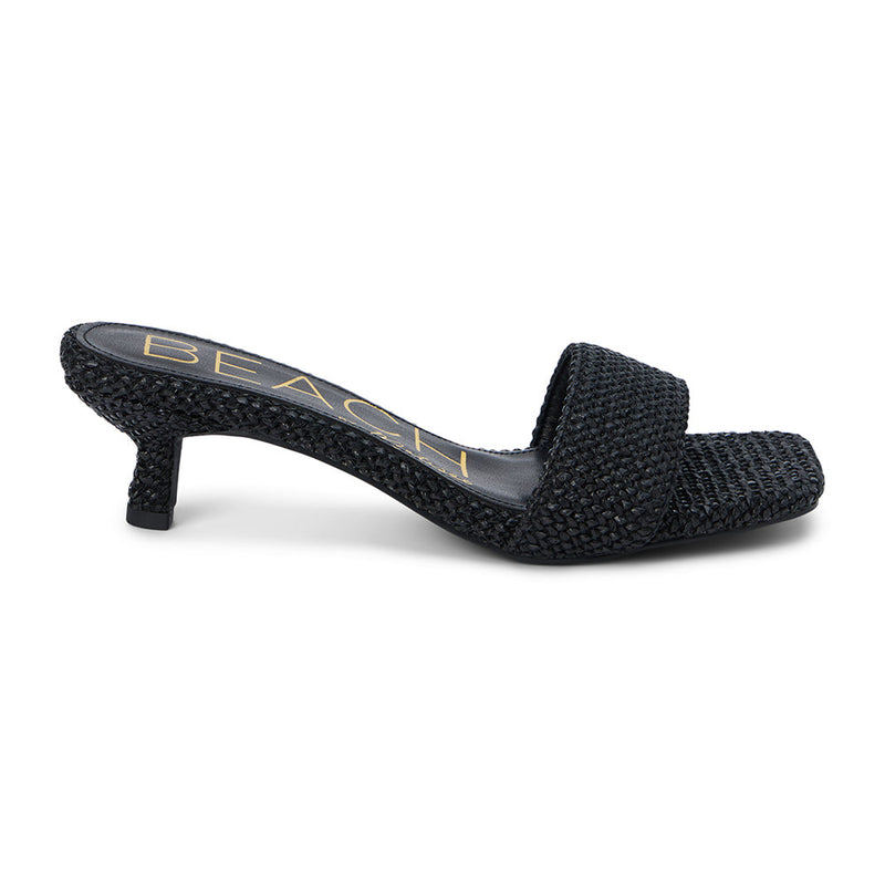 A sleek and modern take on warm-weather style, these black woven kitten heel mules feature a square toe, raffia-inspired texture, and a comfortable low heel. Effortlessly chic for day or night.