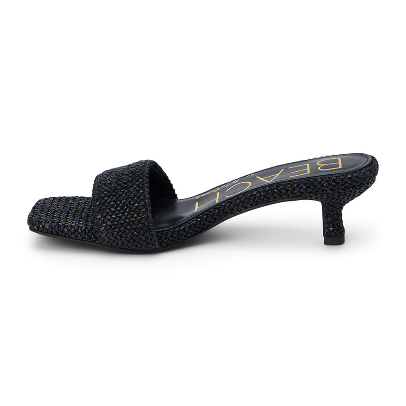 A sleek and modern take on warm-weather style, these black woven kitten heel mules feature a square toe, raffia-inspired texture, and a comfortable low heel. Effortlessly chic for day or night.