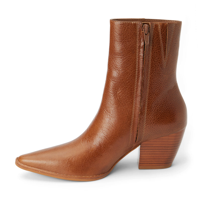 Tan leather ankle boots featuring a pointed toe, stacked block heel, and smooth side panels. A refined take on a Western-inspired silhouette.