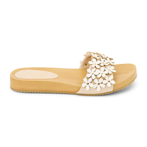 Cream floral-embellished slide sandals with a faux-wood platform sole and delicate daisy appliqués. A charming blend of comfort and whimsy, perfect for effortless warm-weather wear.