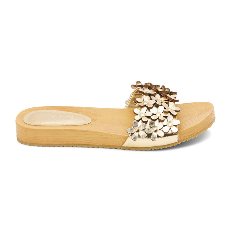 Gold floral-embellished slide sandals with a faux-wood platform sole and metallic daisy appliqués. A playful yet refined style, perfect for effortless warm-weather wear.