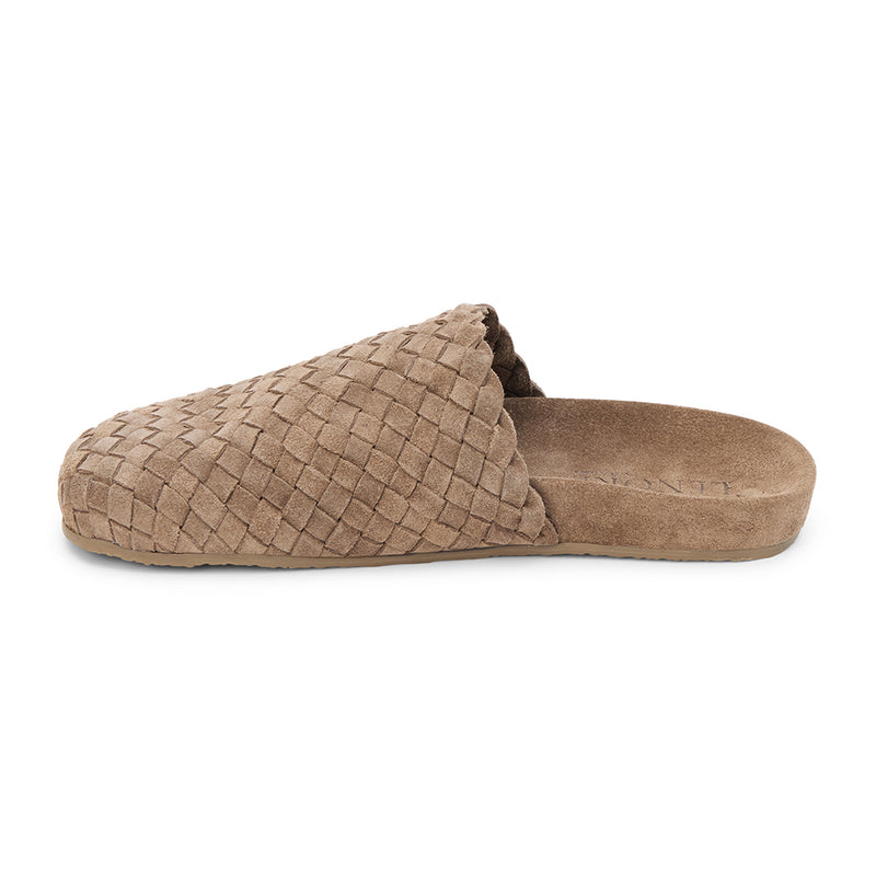 Taupe suede woven mule with a soft texture and cushioned footbed. A cozy yet refined silhouette, perfect for effortless everyday wear.