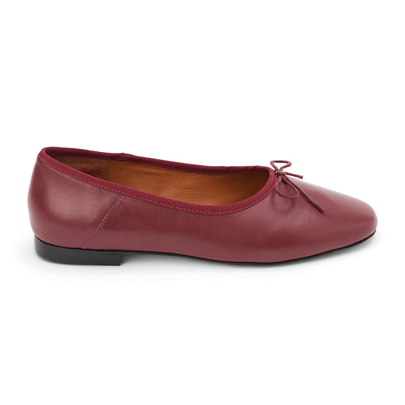 Wine leather ballet flats with a classic round-toe silhouette, delicate bow detail, and padded leather insole. A timeless essential for effortless everyday elegance.