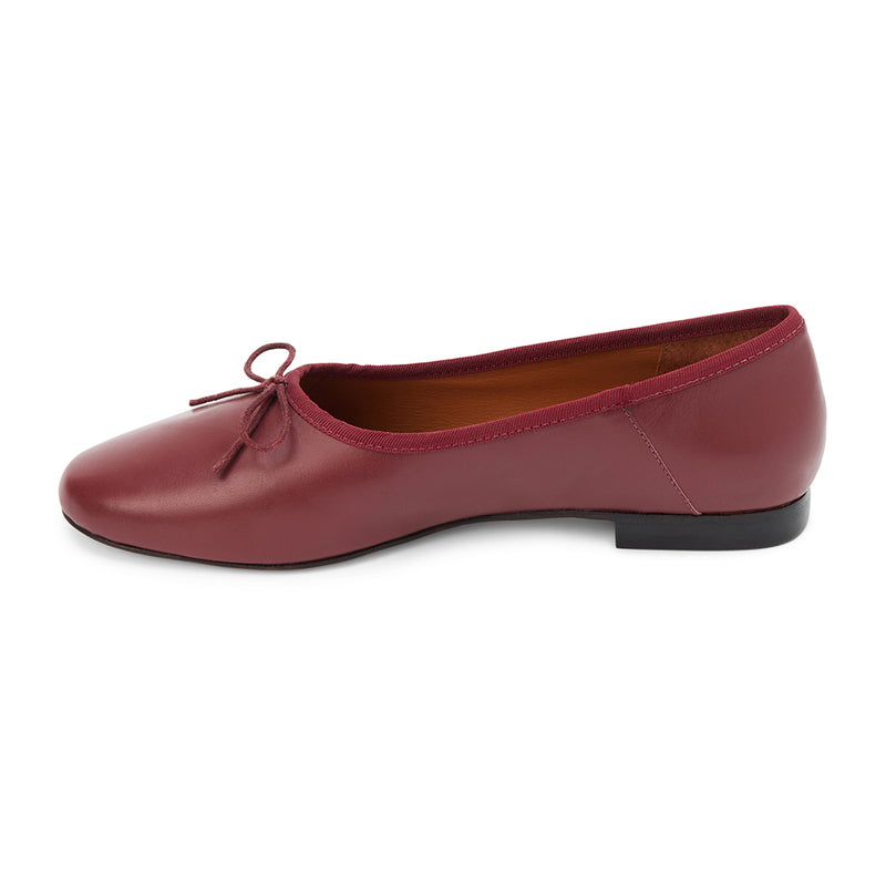 Wine leather ballet flats with a classic round-toe silhouette, delicate bow detail, and padded leather insole. A timeless essential for effortless everyday elegance.