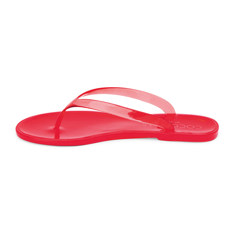 Red jelly flip-flops with transparent straps and a minimalist design. A lightweight, water-friendly essential for effortless summer wear.