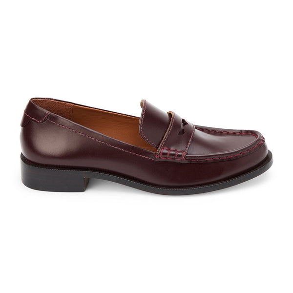 Burgundy leather penny loafers with a polished finish, classic moccasin stitching, and a low stacked heel. A timeless staple for effortless sophistication.